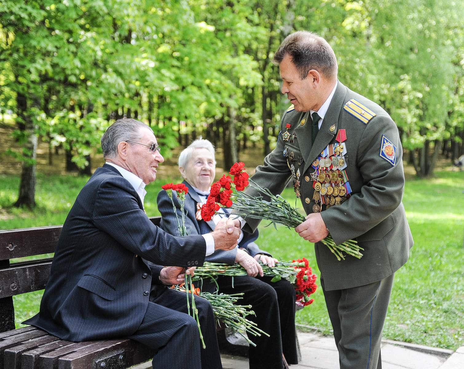 Вице-президент Международной Ассоциации «Альфа» Владимир Елисеев дарит цветы ветеранам. Москва, Поклонная гора. 9 мая 2016 года