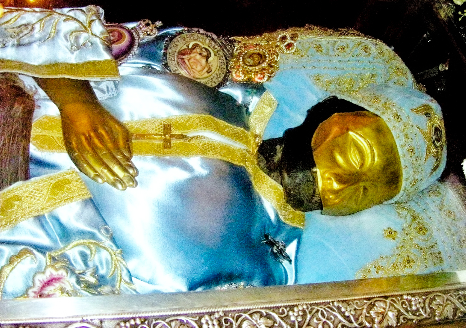 Под стеклом саркофага можно отчётливо рассмотреть убранное парчой и потемневшее тело (мощи) святого Иоанна Русского. Большую часть его лица закрывает золотая пластина