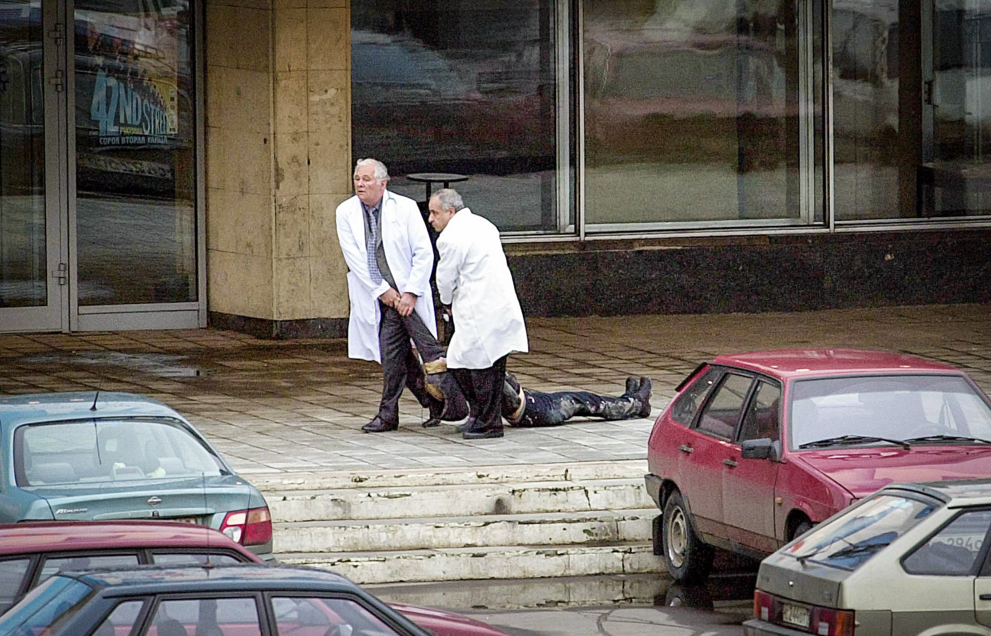 Главный педиатр России Леонид Рошаль и иорданский доктор Анвар эль-Саид вытаскивают тело расстрелянной террористами Ольги Романовой. 24 октября 2002 года
